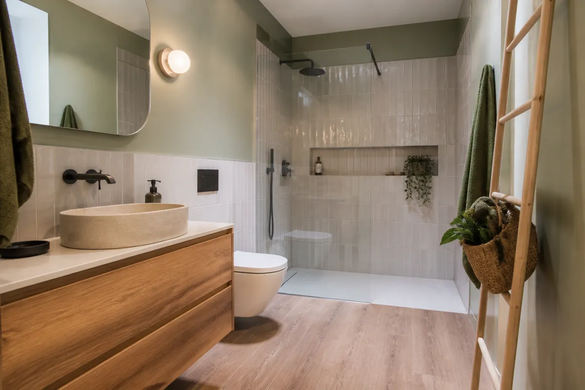Baño reformado con zona de ducha amplia y espacio libre de circulación